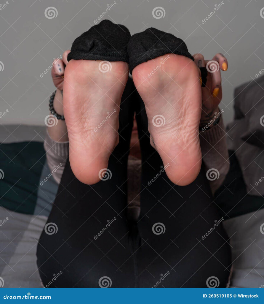 Closeup Of The Soles Of Female Feet With Socks Lying In A Bed Stock 